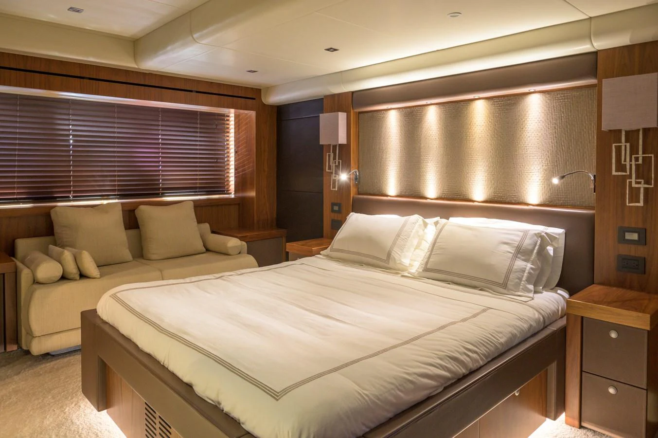 The master stateroom features a luxurious bed with elegant lighting and a comfortable seating area. aboard EBRA Yacht for Sale