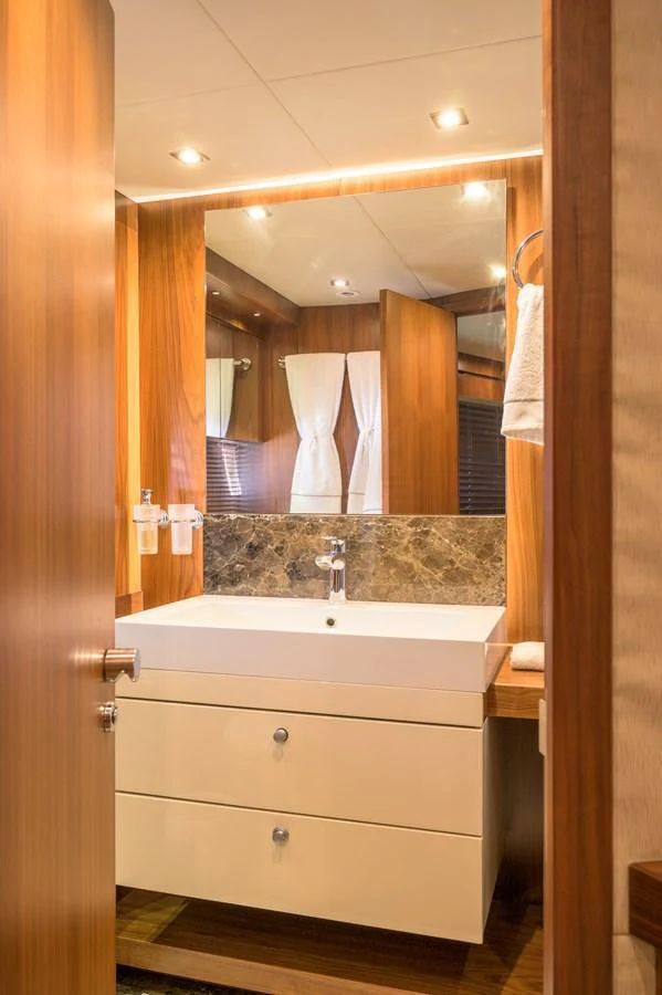 The yacht's bathroom features modern fixtures and elegant wood paneling. aboard EBRA Yacht for Sale