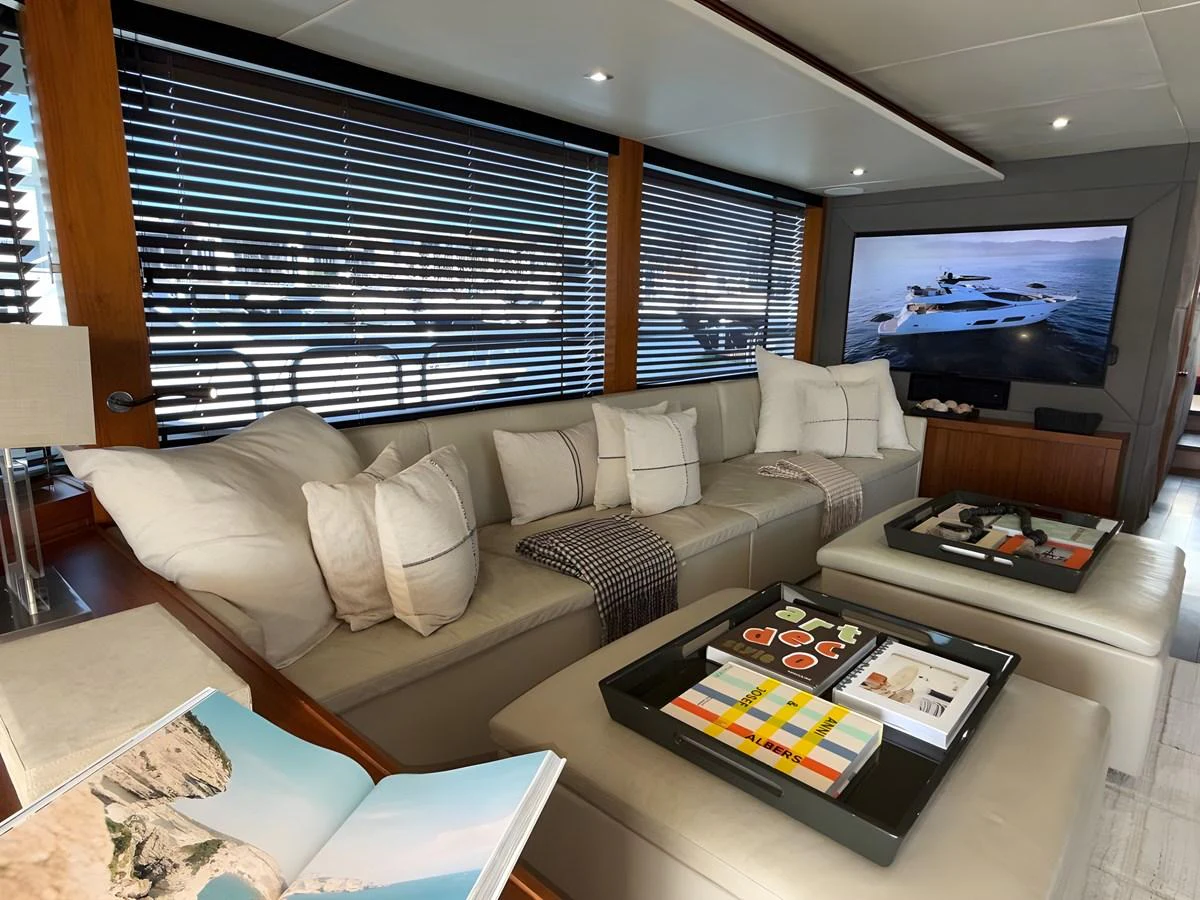The salon features a comfortable seating area with a large TV and modern decor. aboard EBRA Yacht for Sale