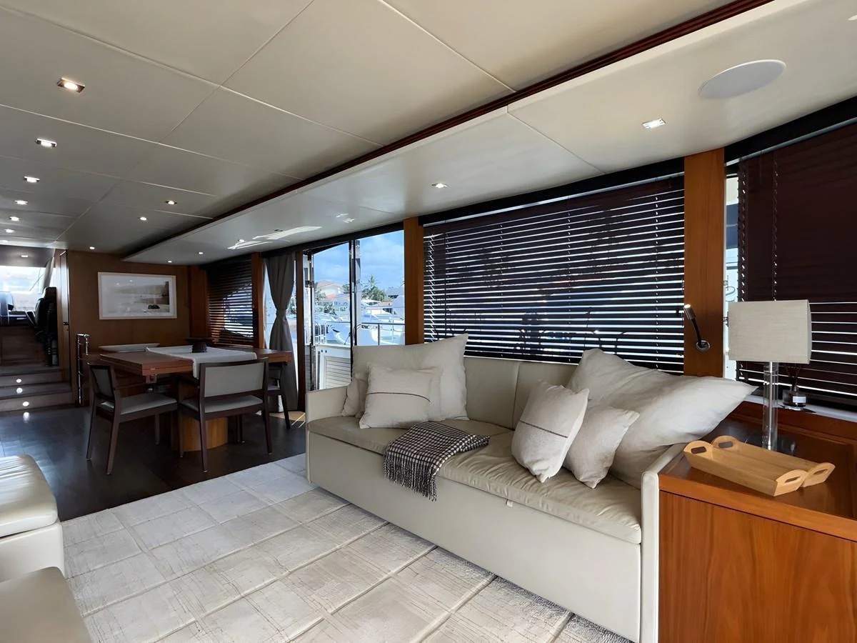 The salon features a comfortable seating area with large windows and elegant decor. aboard EBRA Yacht for Sale