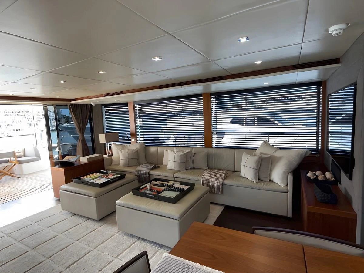 The salon features a spacious and elegant seating area with large windows offering ample natural light. aboard EBRA Yacht for Sale
