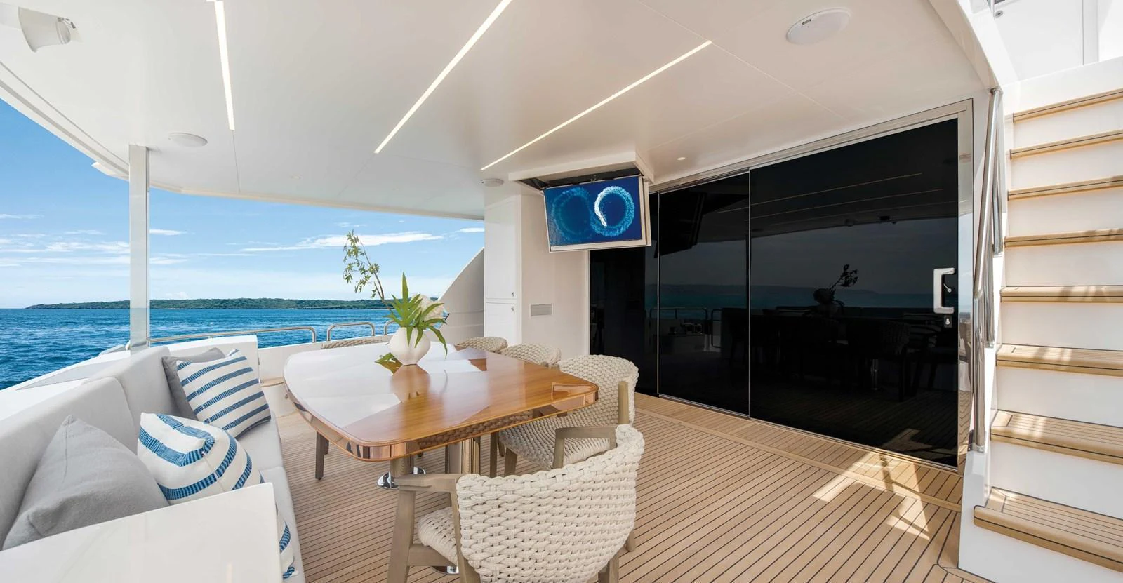 The aft deck features a stylish dining area with comfortable seating and a view of the sea. aboard HORIZON FD80-617 / COMING FALL 2025 Yacht for Sale