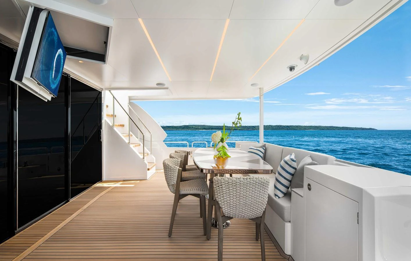 The aft deck features a stylish dining area with a view of the open sea. aboard HORIZON FD80-617 / COMING FALL 2025 Yacht for Sale