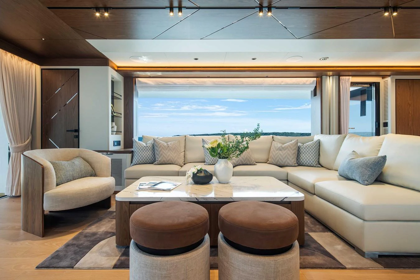 The salon offers a spacious and elegantly designed seating area with a stunning view through large windows. aboard HORIZON FD80-617 / COMING FALL 2025 Yacht for Sale