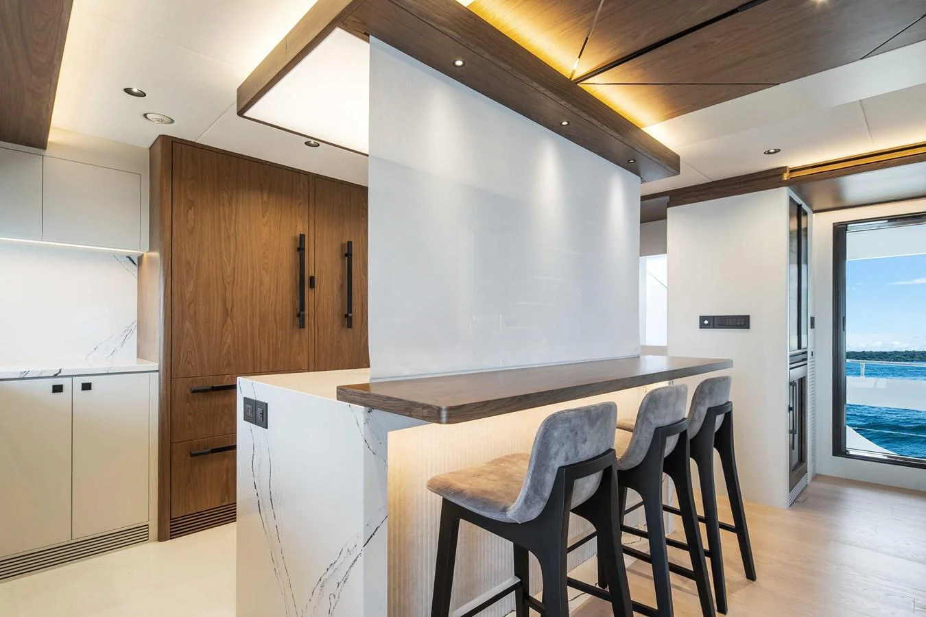 The modern galley features sleek wood finishes, a breakfast bar, and ample natural light. aboard HORIZON FD80-617 / COMING FALL 2025 Yacht for Sale