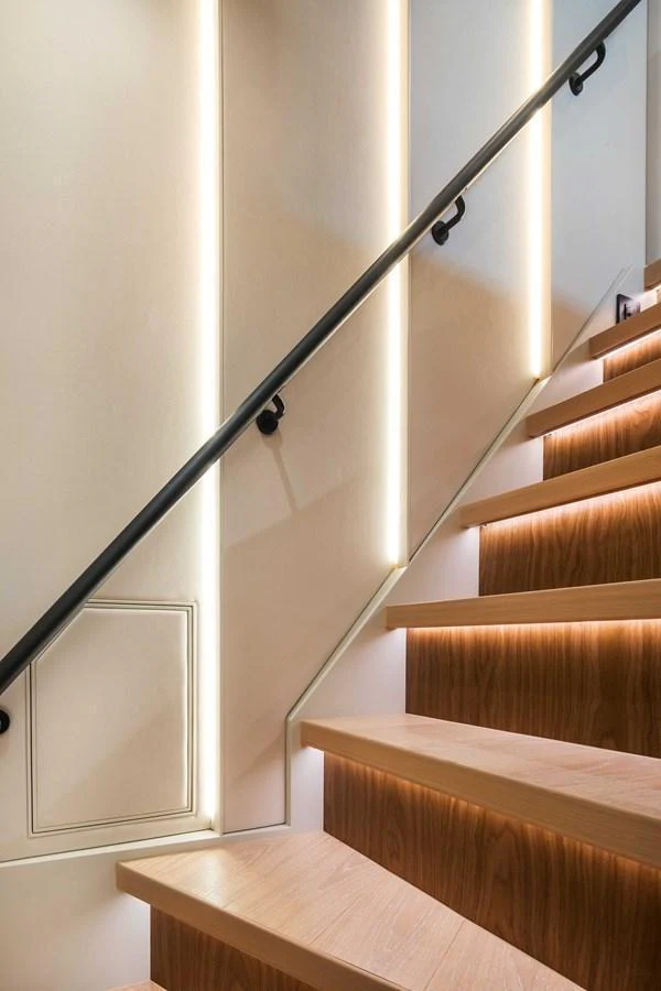 A modern staircase with wooden steps and sleek lighting enhances the yacht's interior elegance. aboard HORIZON FD80-617 / COMING FALL 2025 Yacht for Sale