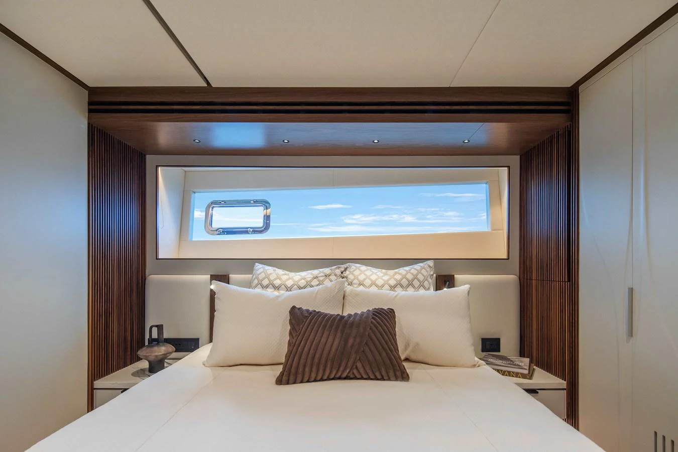 A luxurious stateroom featuring a large bed with plush pillows and a scenic window view. aboard HORIZON FD80-617 / COMING FALL 2025 Yacht for Sale