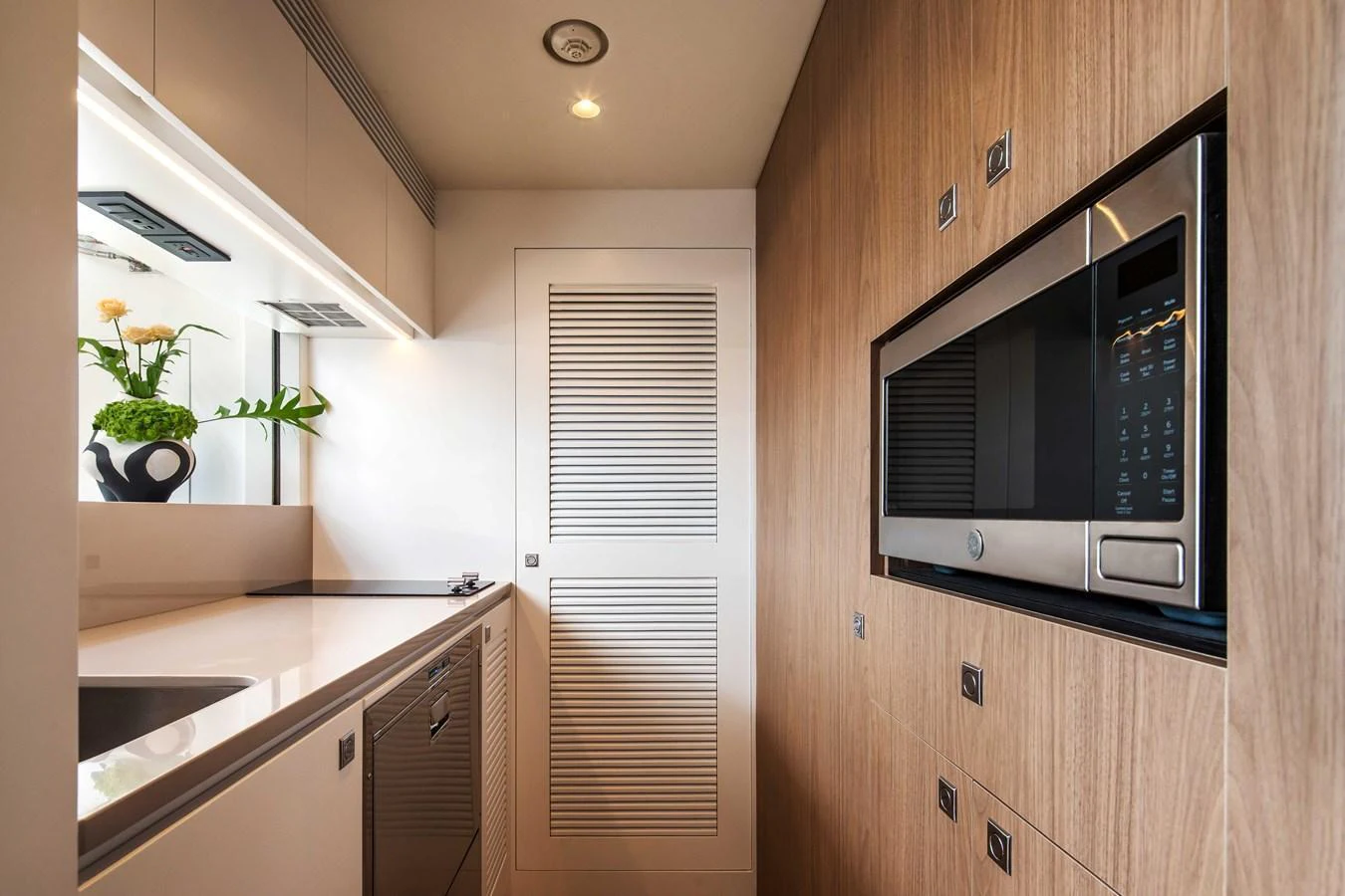 The yacht's galley features modern appliances and sleek wooden cabinetry. aboard HORIZON FD80-617 / COMING FALL 2025 Yacht for Sale