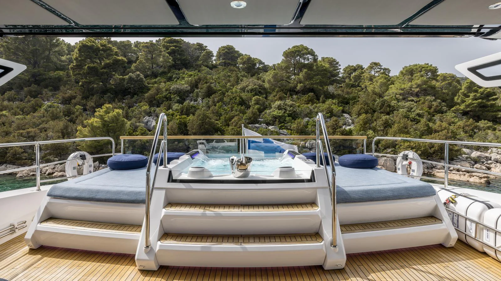 a pool with a deck and trees in the background aboard EXIT Yacht for Sale