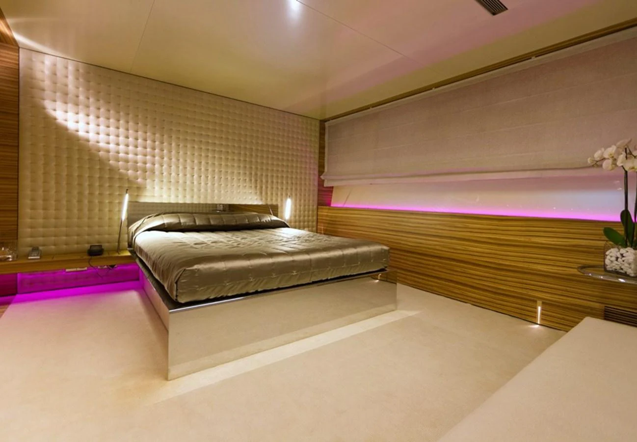 The stateroom features a luxurious bed with modern lighting and elegant decor. aboard MABROUK Yacht for Sale