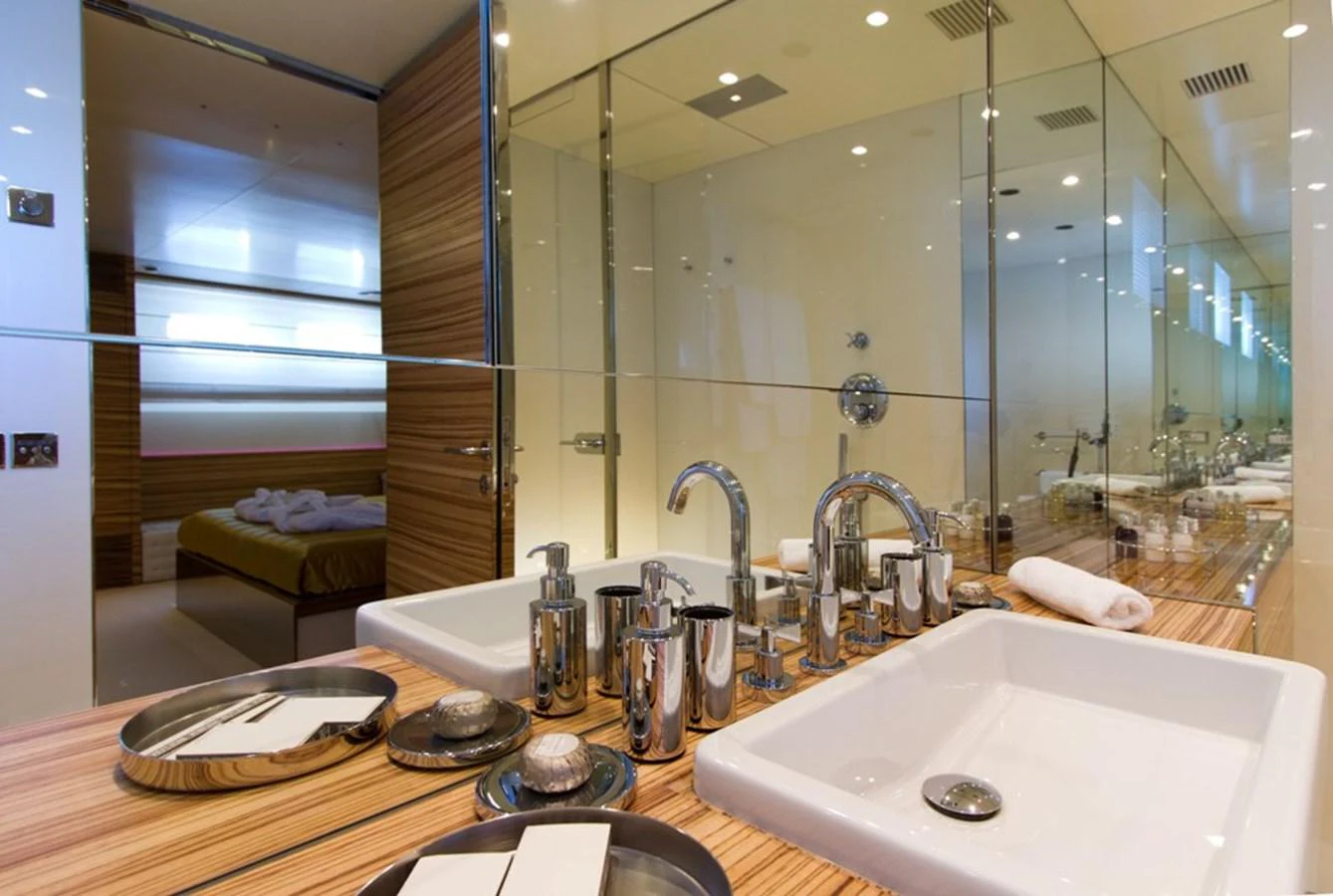 The yacht's bathroom features modern fixtures and a sleek design with a spacious mirror and elegant sink area. aboard MABROUK Yacht for Sale