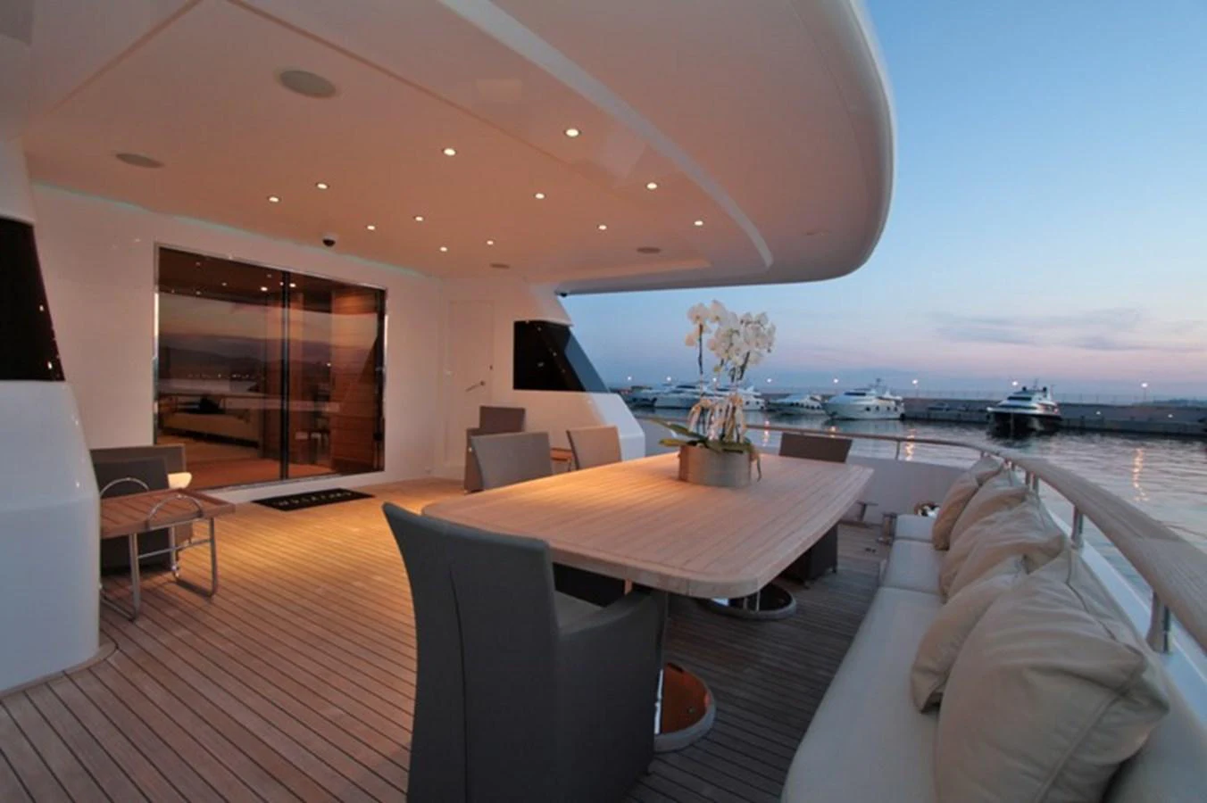 The aft deck offers a spacious and elegant outdoor dining area with a serene view of the marina. aboard MABROUK Yacht for Sale