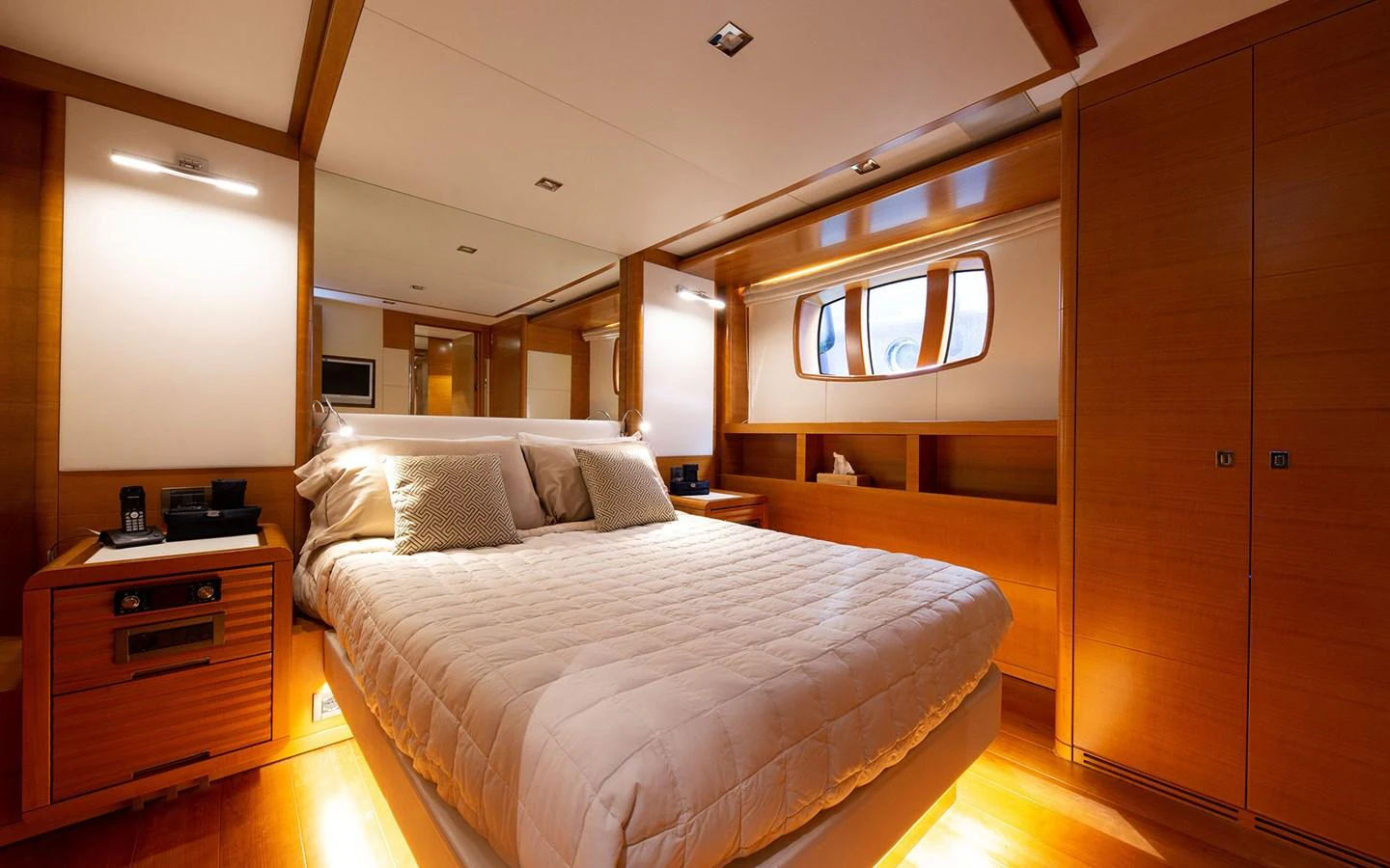 The master stateroom features a luxurious bed with warm wood accents and ample natural light. aboard SOFIA OF TORTOLA Yacht for Sale