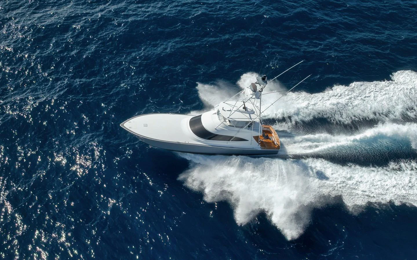 A sleek yacht cruises swiftly over the deep blue ocean, leaving a trail of white wake behind. aboard LADY SURFBUM Yacht for Sale