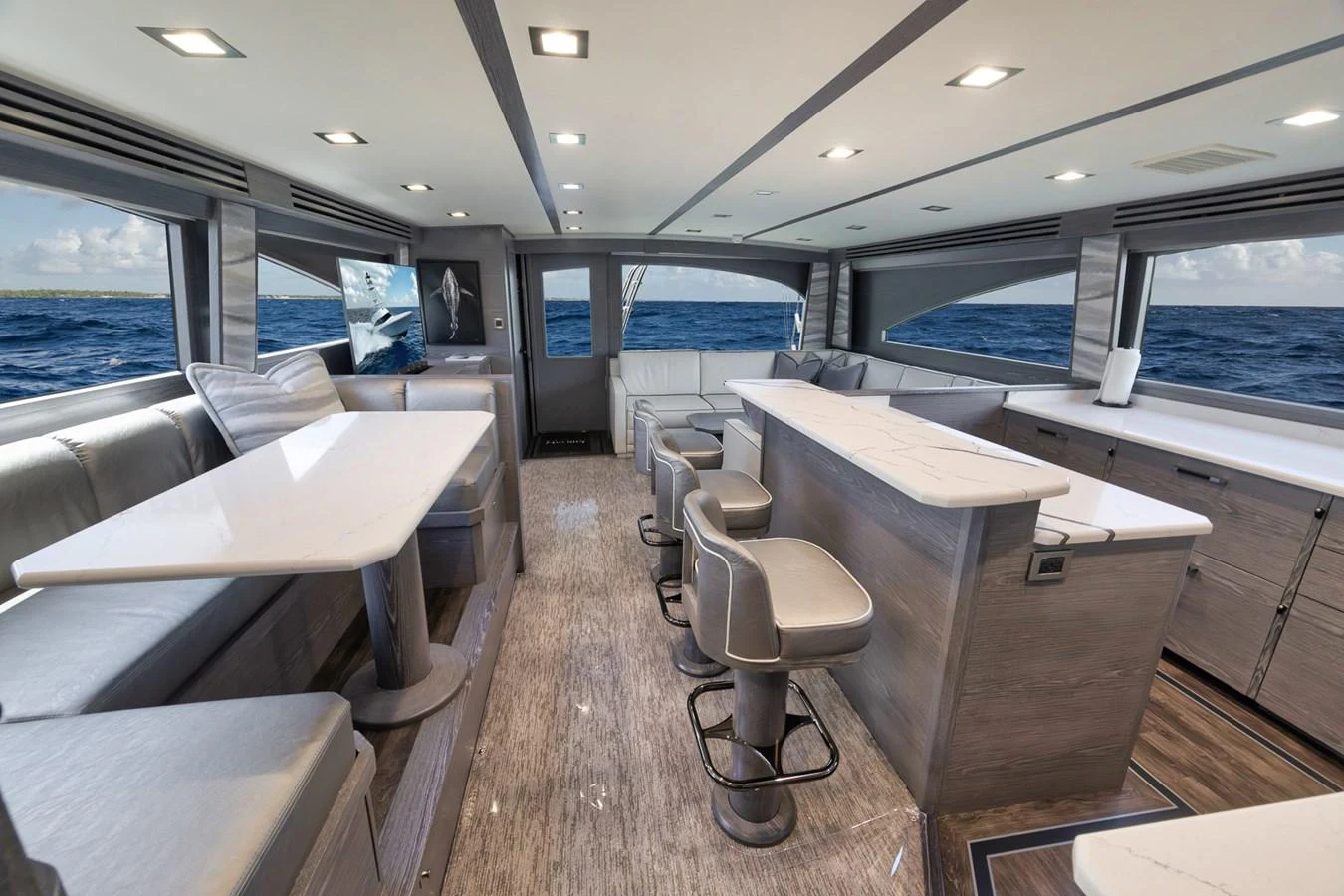 The yacht's salon features a spacious and modern design with ample seating and large windows offering stunning ocean views. aboard LADY SURFBUM Yacht for Sale
