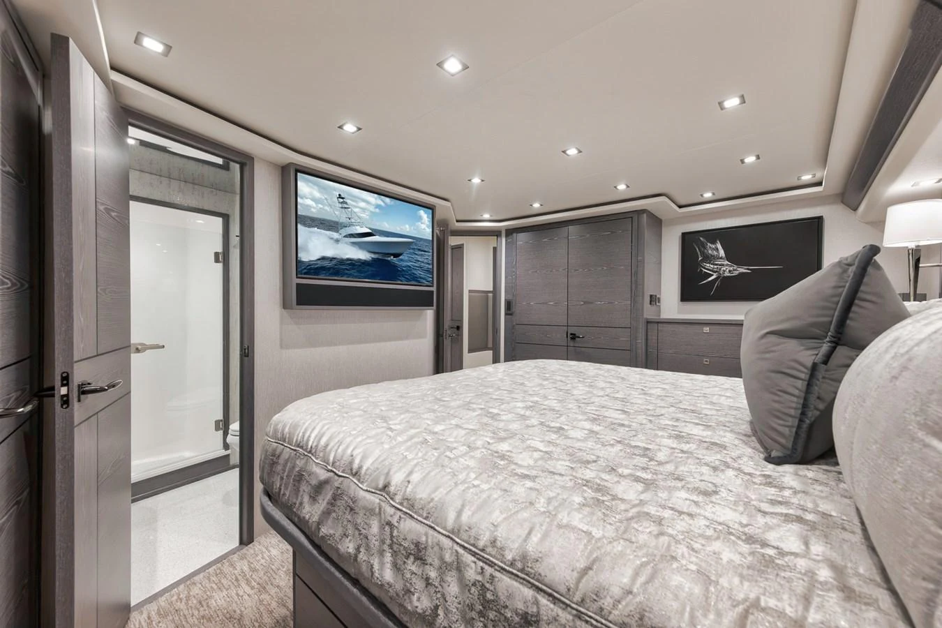 The master stateroom features a luxurious bed, modern decor, and ample lighting. aboard LADY SURFBUM Yacht for Sale
