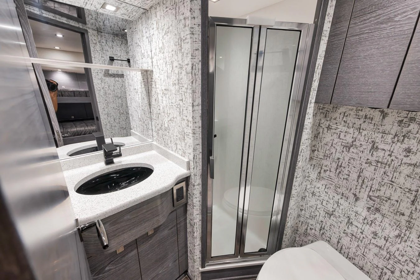 A modern yacht bathroom featuring a sleek vanity and a glass-enclosed shower. aboard LADY SURFBUM Yacht for Sale