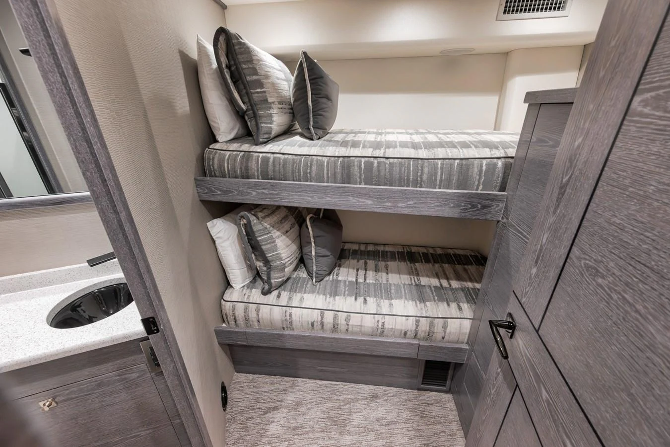 The cozy bunk room features neatly arranged beds with striped bedding and ample storage space. aboard LADY SURFBUM Yacht for Sale