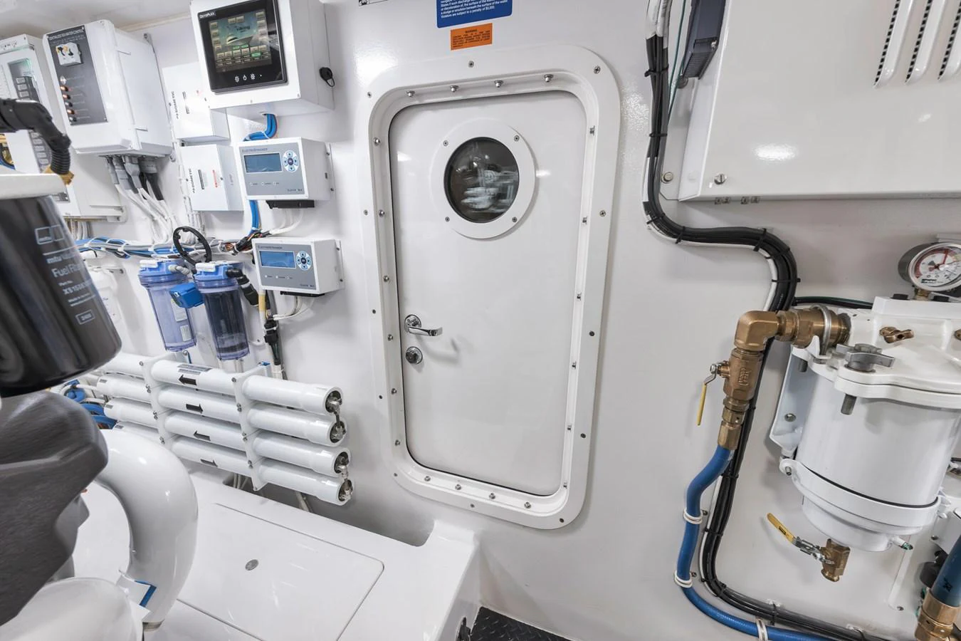 The image showcases the yacht's engine room with various technical equipment and a secure door. aboard LADY SURFBUM Yacht for Sale