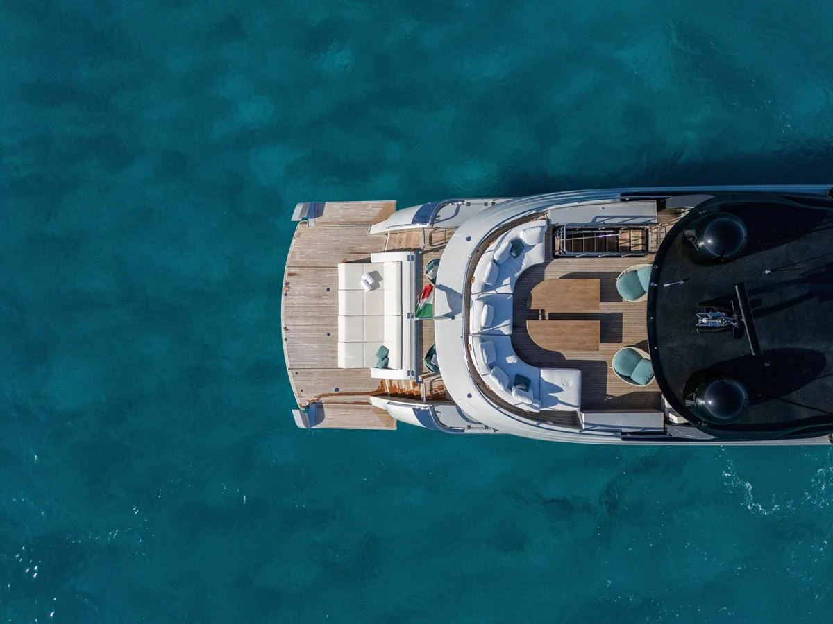 A stunning aerial view of the yacht's aft deck, showcasing a spacious lounging area over clear blue waters. aboard FILIPPETTI F100-03 Yacht for Sale