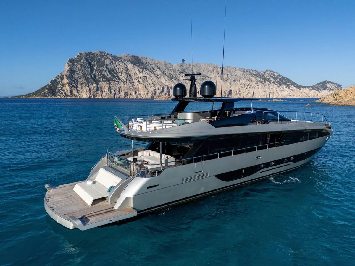 A sleek and modern yacht cruising in clear blue waters with a stunning rocky coastline in the background. aboard FILIPPETTI F100-03 Yacht for Sale