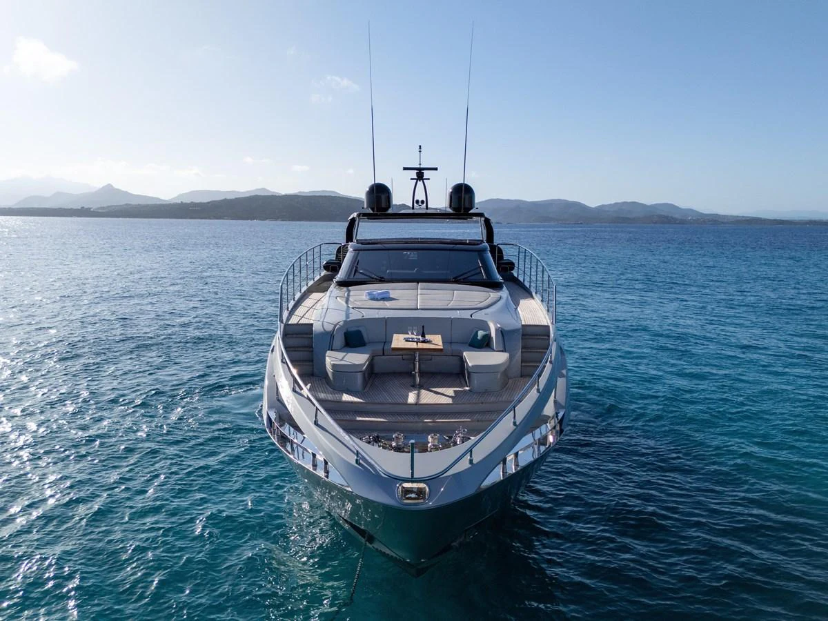 A sleek yacht is anchored in calm, clear waters with a stunning backdrop of distant mountains. aboard FILIPPETTI F100-03 Yacht for Sale