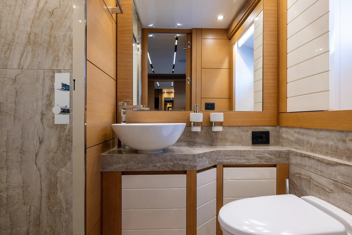 The yacht's bathroom features a modern sink and elegant wood paneling. aboard FILIPPETTI F100-03 Yacht for Sale