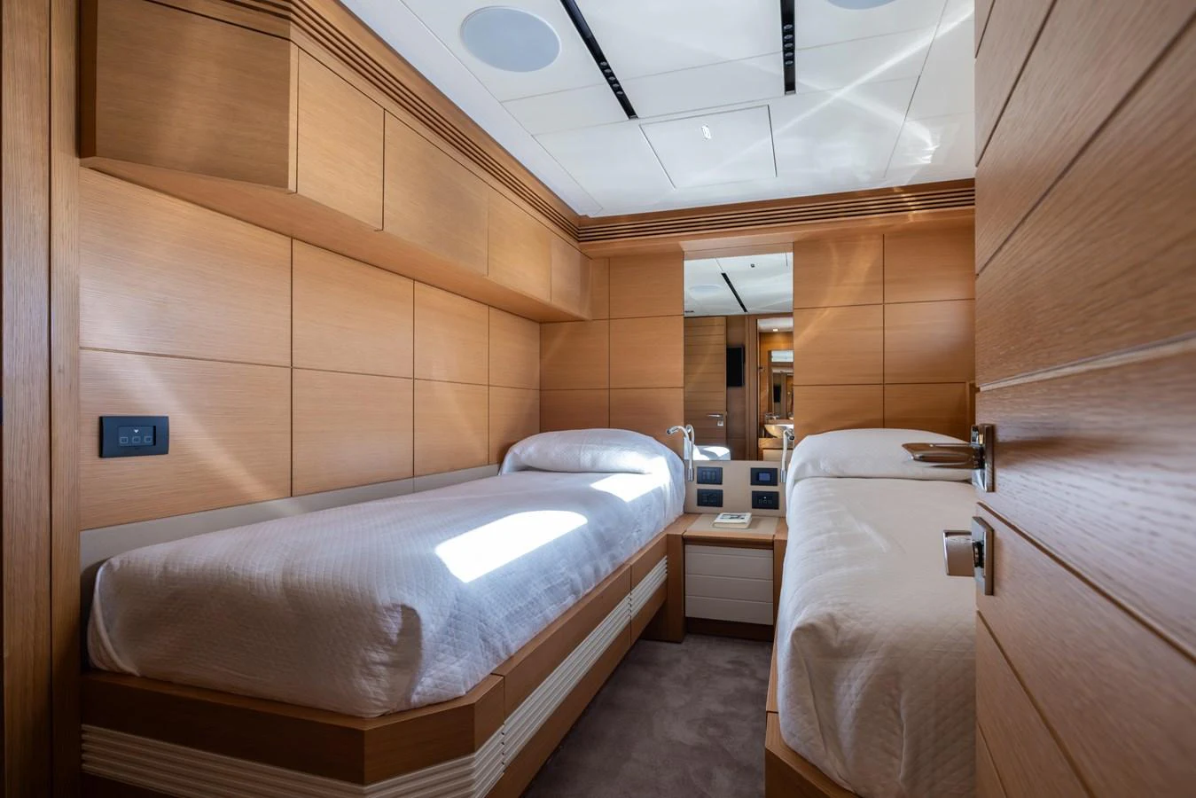 The twin stateroom features two single beds with modern wooden paneling and ample storage. aboard FILIPPETTI F100-03 Yacht for Sale
