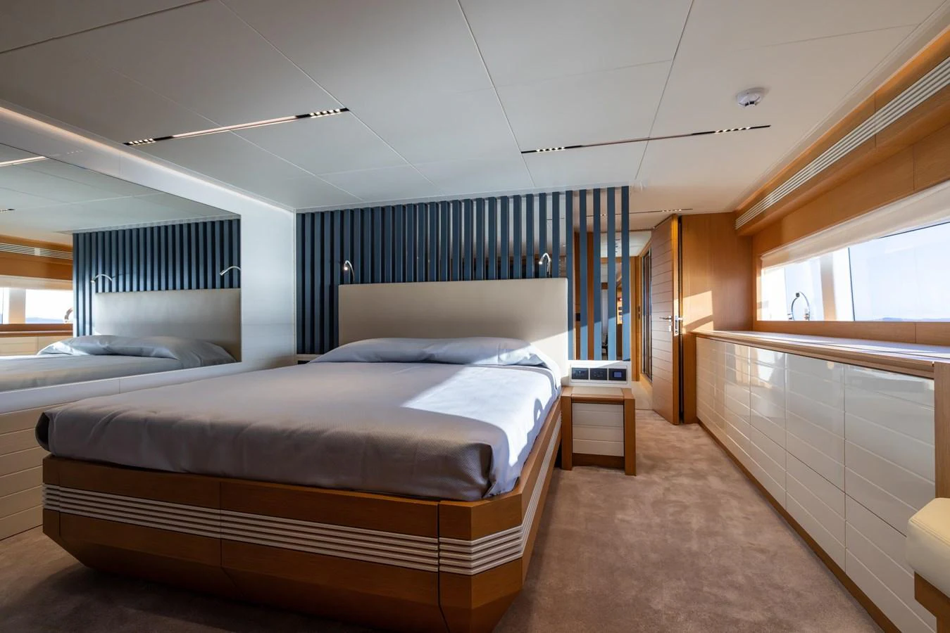 The stateroom features a luxurious bed with modern design elements and ample natural light. aboard FILIPPETTI F100-03 Yacht for Sale
