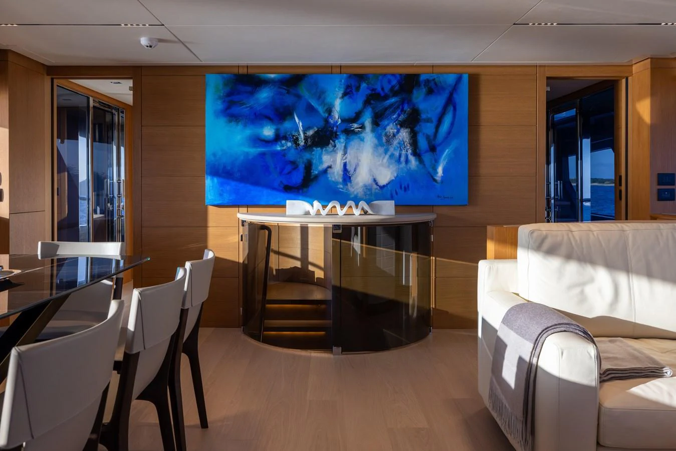 The salon features modern decor with a striking blue abstract painting as a focal point. aboard FILIPPETTI F100-03 Yacht for Sale