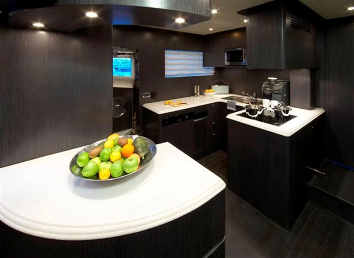 The yacht's galley features modern appliances and sleek dark cabinetry, creating a sophisticated culinary space. aboard JOHNSON 83’ SKYLOUNGE W/FISHING COCKPIT Yacht for Sale
