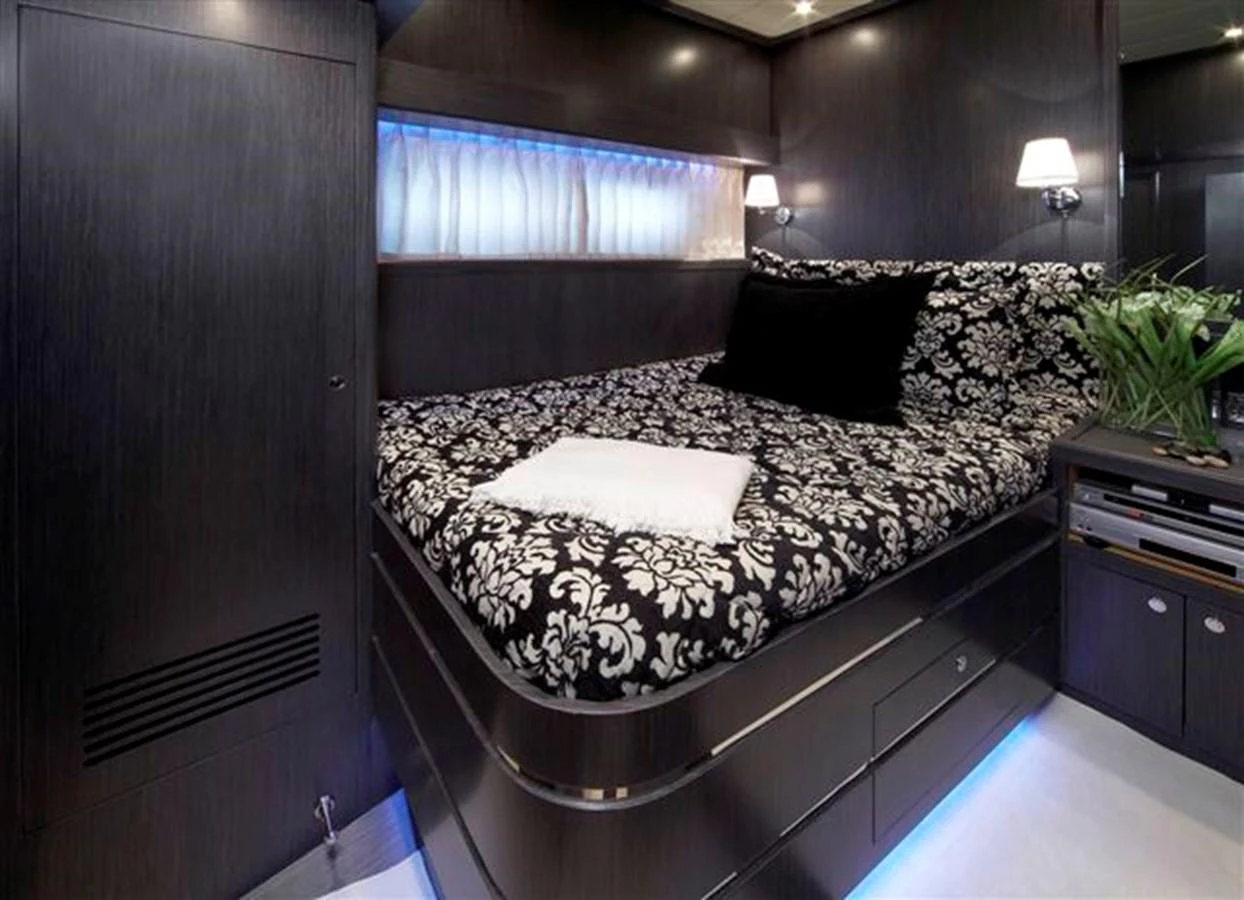 A luxurious stateroom featuring a stylish bed with patterned bedding and ambient lighting. aboard JOHNSON 83’ SKYLOUNGE W/FISHING COCKPIT Yacht for Sale