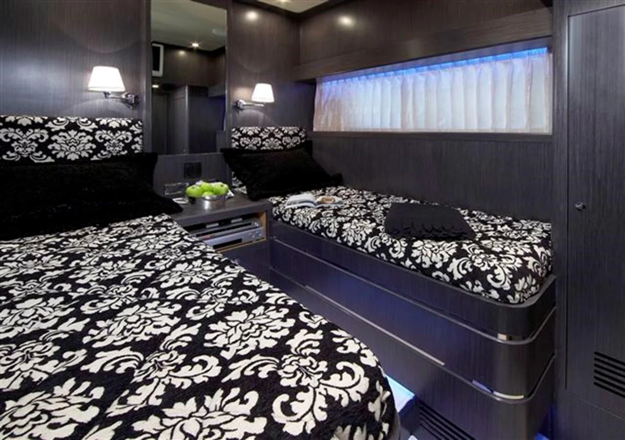 The guest stateroom features twin beds with elegant patterned bedding and modern lighting. aboard JOHNSON 83’ SKYLOUNGE W/FISHING COCKPIT Yacht for Sale