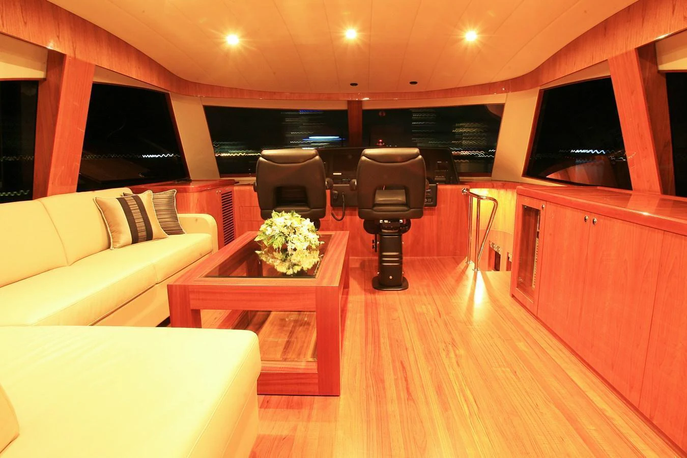 The helm area features luxurious wood finishes and comfortable seating, creating an inviting atmosphere for navigation. aboard JOHNSON 83’ SKYLOUNGE W/FISHING COCKPIT Yacht for Sale