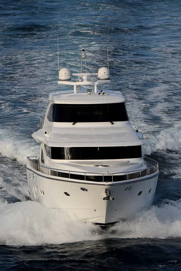 A sleek yacht cruises forward through the water, showcasing its elegant design and powerful performance. aboard JOHNSON 83’ SKYLOUNGE W/FISHING COCKPIT Yacht for Sale