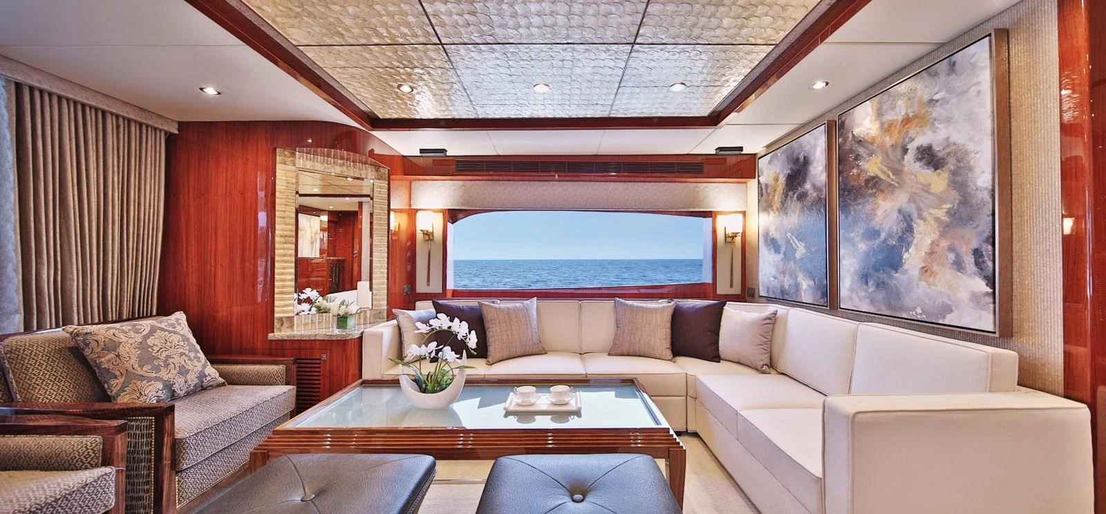 The salon features a spacious seating area with elegant decor and a stunning ocean view. aboard JOHNSON 83' FLYBRIDGE W/HYDRAULIC PLATFORM Yacht for Sale
