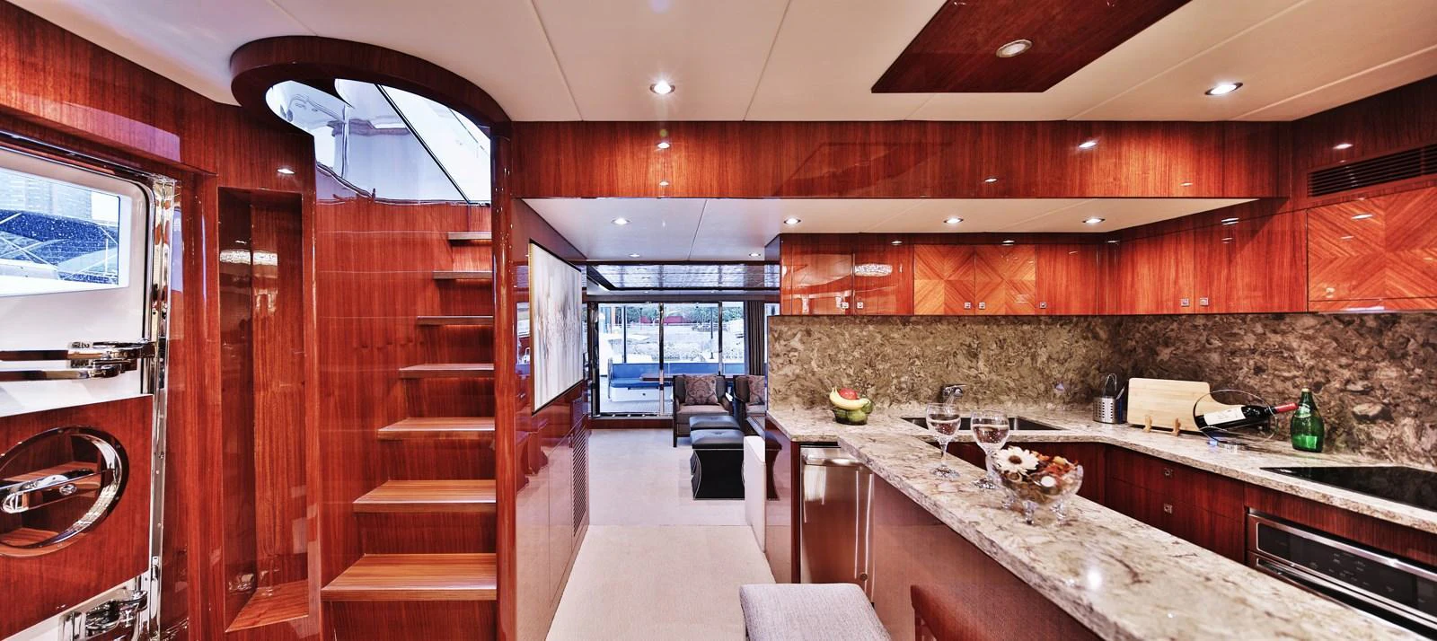 The yacht's galley features luxurious wood finishes and modern amenities, creating a warm and inviting atmosphere. aboard JOHNSON 83' FLYBRIDGE W/HYDRAULIC PLATFORM Yacht for Sale