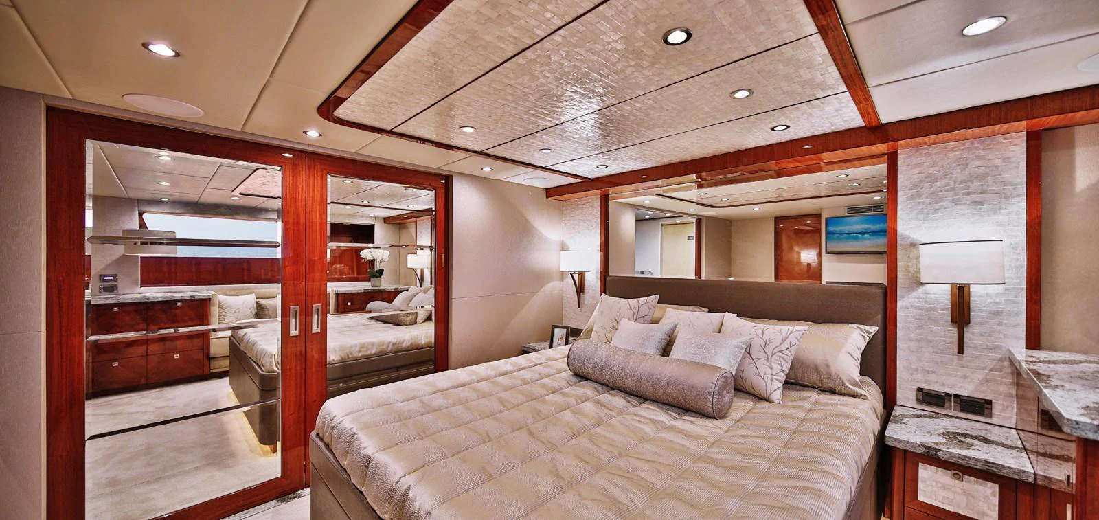 The master stateroom features a luxurious bed with elegant wood accents and ample lighting. aboard JOHNSON 83' FLYBRIDGE W/HYDRAULIC PLATFORM Yacht for Sale