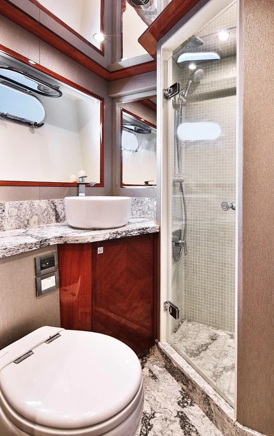 The yacht's bathroom features a sleek design with a modern shower, elegant sink, and luxurious marble surfaces. aboard JOHNSON 83' FLYBRIDGE W/HYDRAULIC PLATFORM Yacht for Sale
