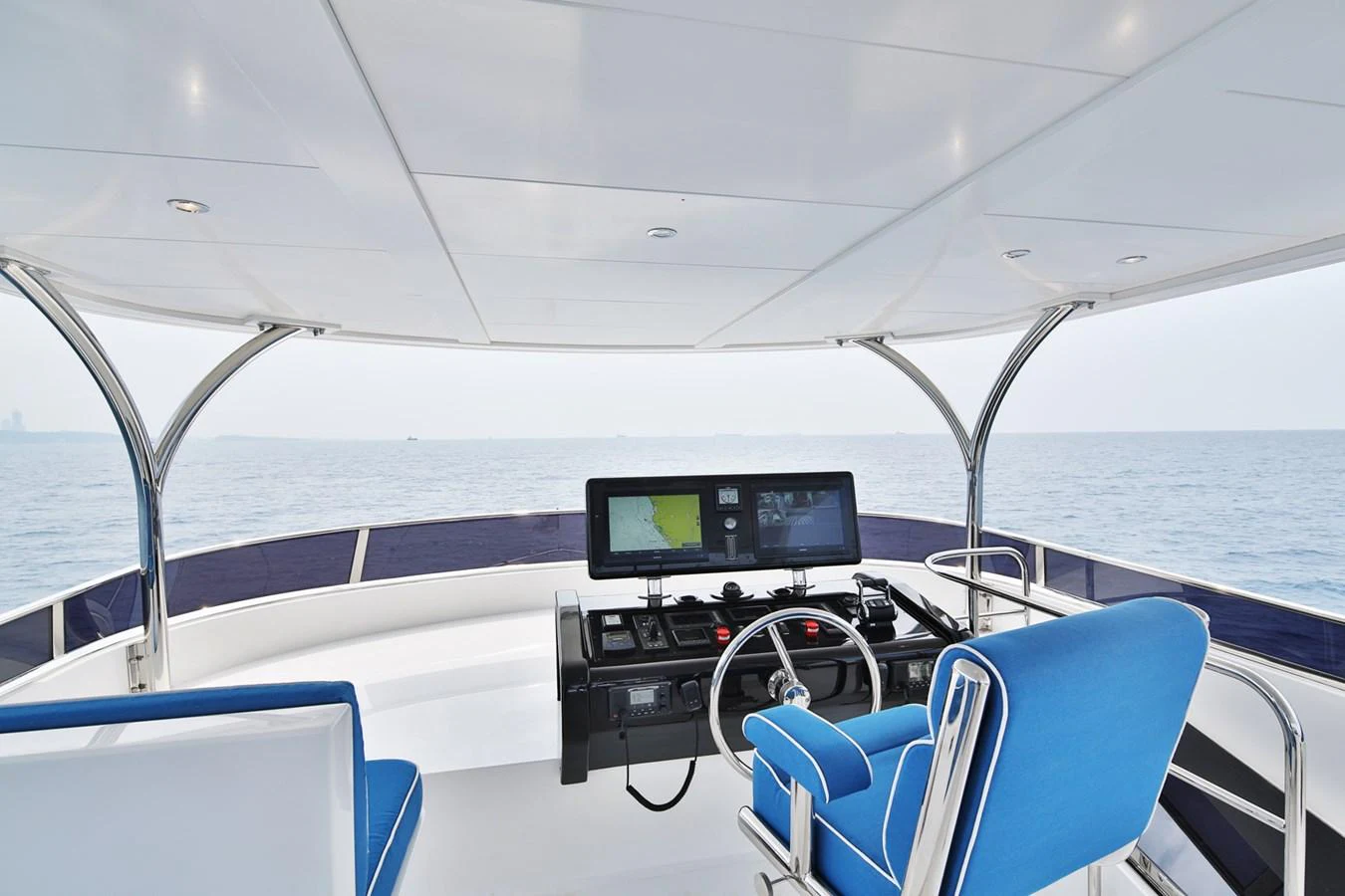 The yacht's helm features modern navigation equipment and comfortable seating with a panoramic view of the sea. aboard JOHNSON 83' FLYBRIDGE W/HYDRAULIC PLATFORM Yacht for Sale
