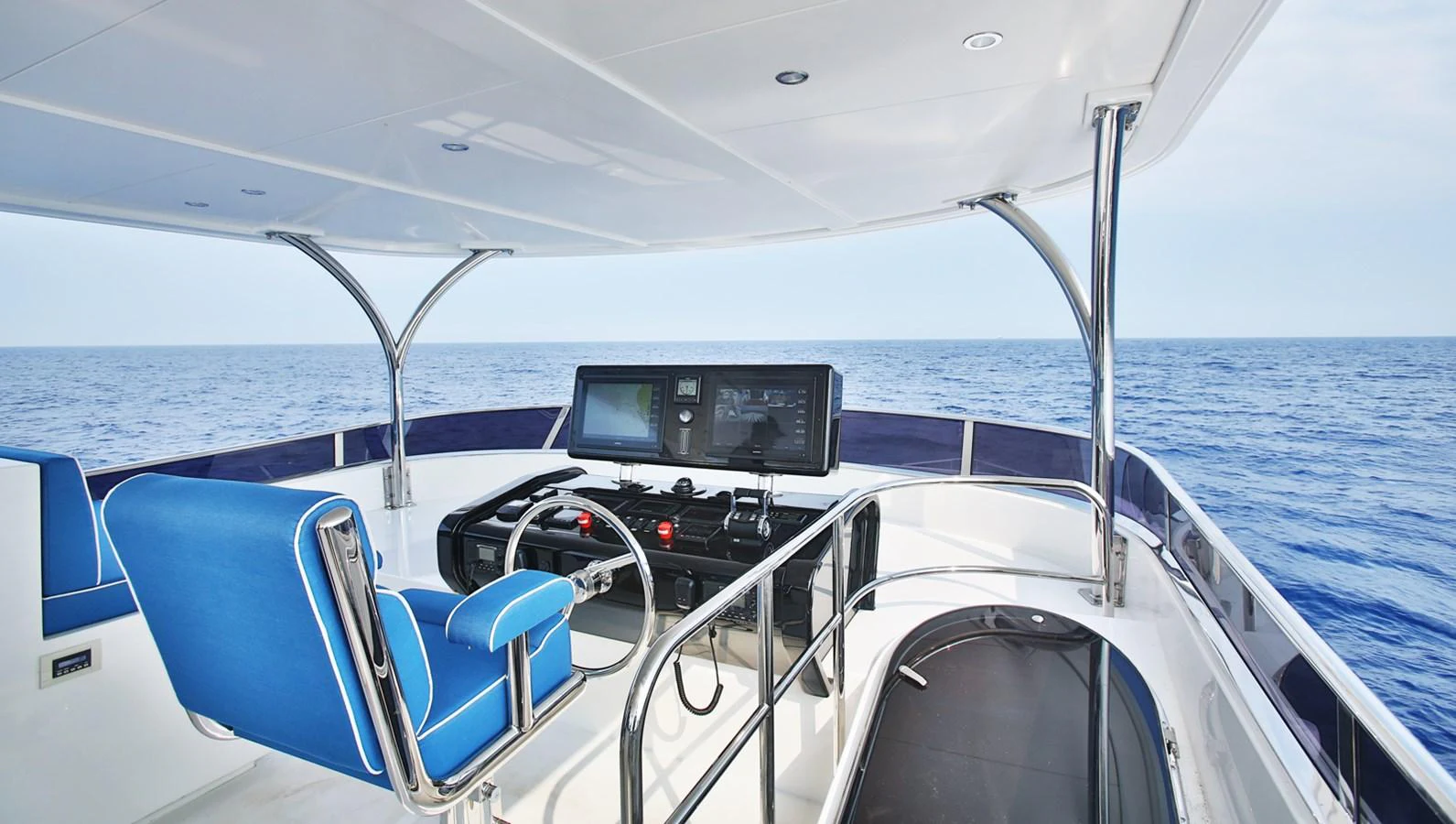 The yacht's helm station offers a sleek and modern design with panoramic ocean views. aboard JOHNSON 83' FLYBRIDGE W/HYDRAULIC PLATFORM Yacht for Sale