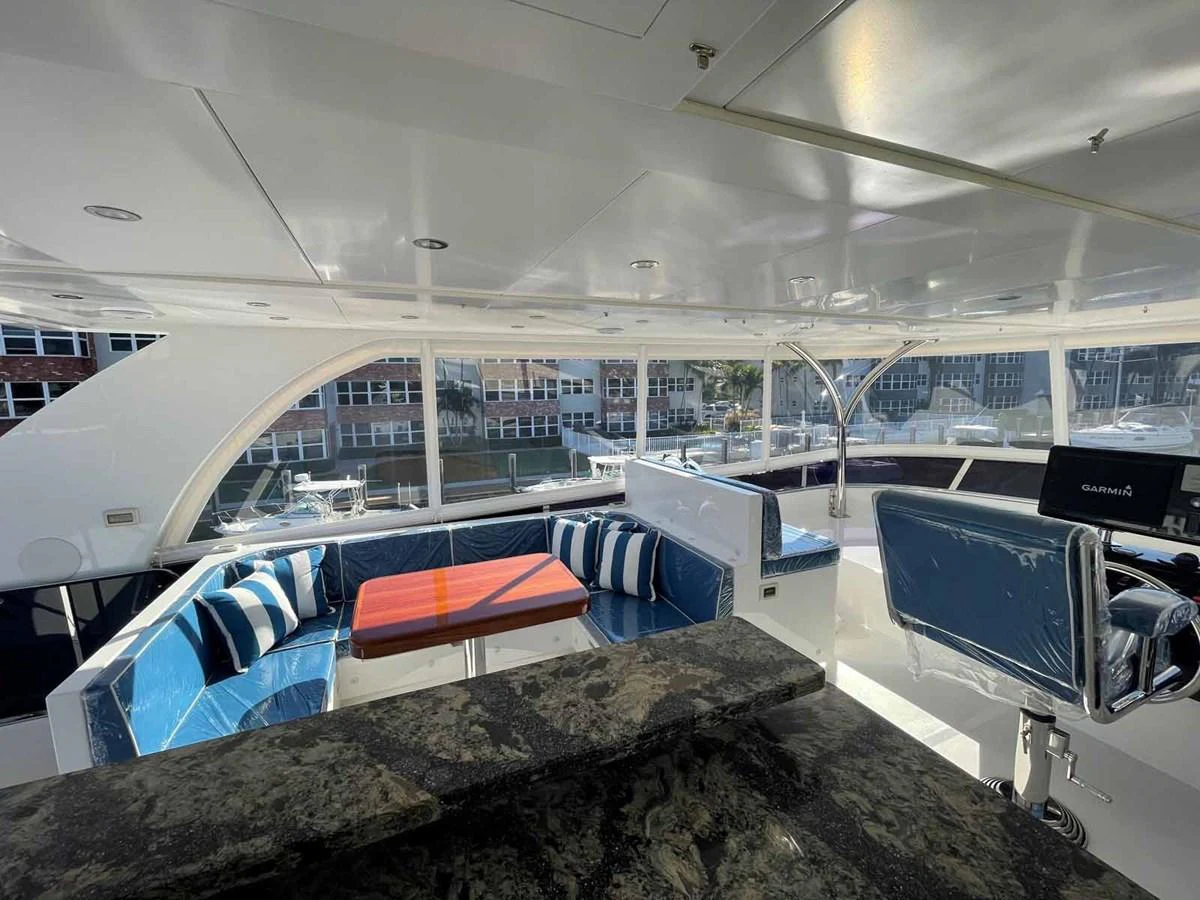 The flybridge features a spacious seating area with plush cushions and a sleek helm station. aboard JOHNSON 83' FLYBRIDGE W/HYDRAULIC PLATFORM Yacht for Sale
