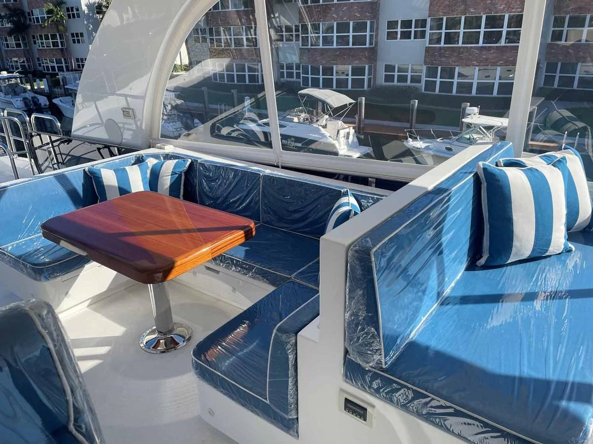 The yacht features a cozy seating area with blue and white cushions, perfect for relaxation. aboard JOHNSON 83' FLYBRIDGE W/HYDRAULIC PLATFORM Yacht for Sale