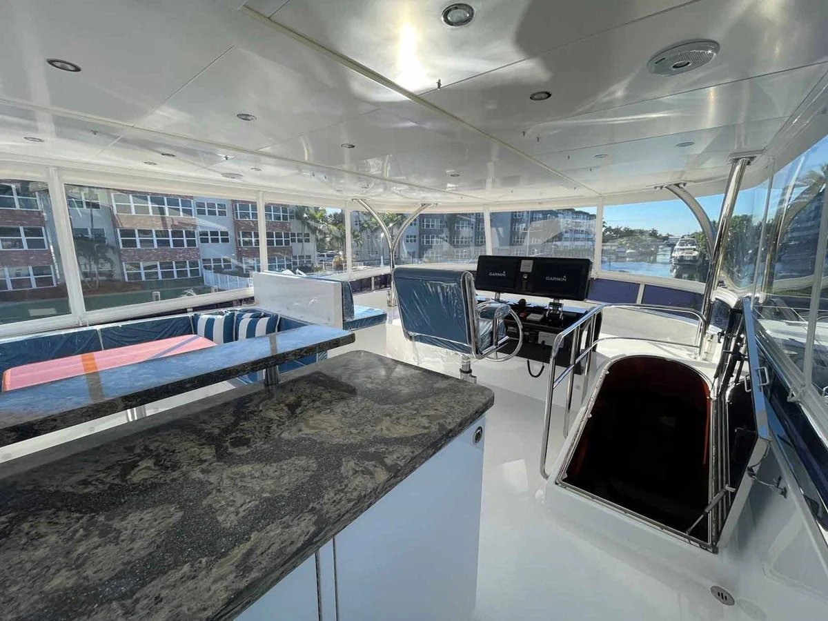 The helm area features a sleek design with modern controls and a spacious layout for navigation and relaxation. aboard JOHNSON 83' FLYBRIDGE W/HYDRAULIC PLATFORM Yacht for Sale