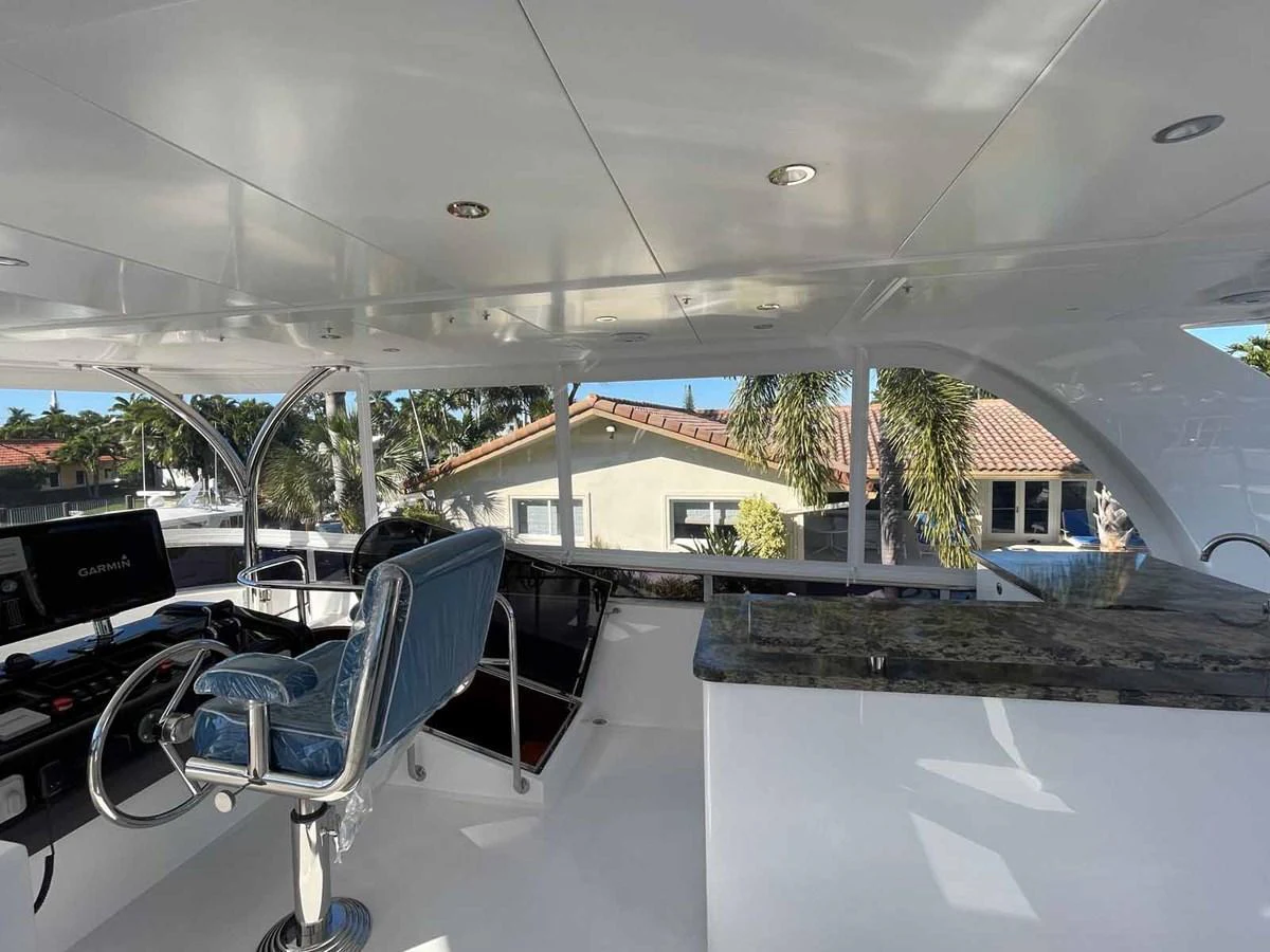 The helm area features a sleek design with modern navigation equipment and a comfortable captain's chair. aboard JOHNSON 83' FLYBRIDGE W/HYDRAULIC PLATFORM Yacht for Sale