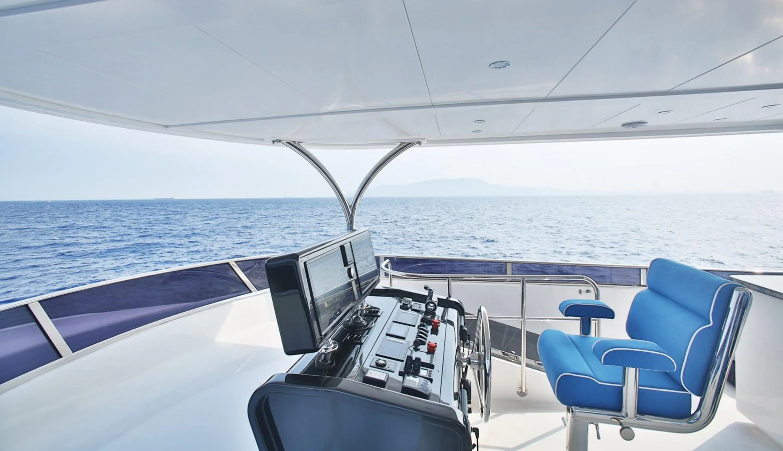The yacht's helm offers a modern and open view of the sea, featuring comfortable seating and advanced navigation equipment. aboard JOHNSON 83' FLYBRIDGE W/HYDRAULIC PLATFORM Yacht for Sale