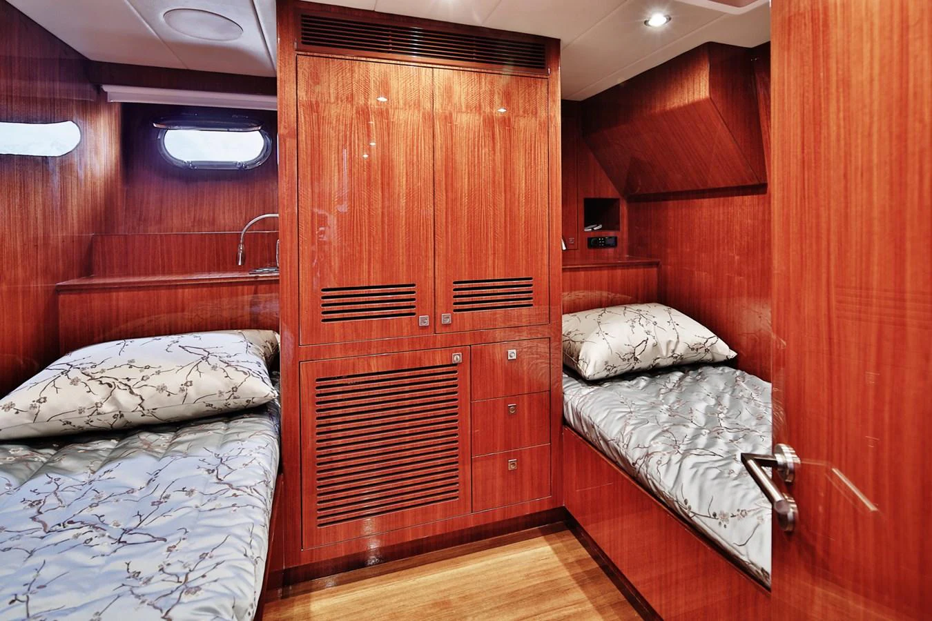 The guest cabin features twin beds with elegant wood paneling and soft lighting. aboard JOHNSON 83' FLYBRIDGE W/HYDRAULIC PLATFORM Yacht for Sale