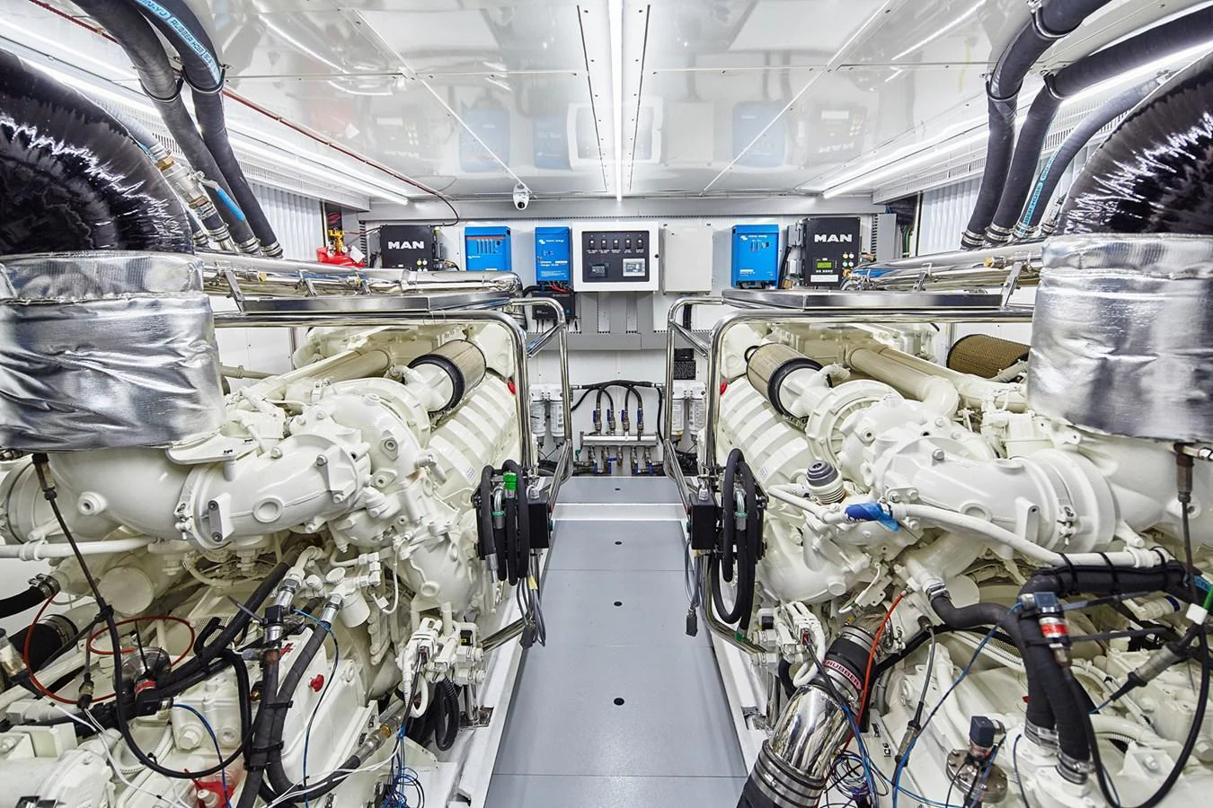 The image showcases a pristine engine room with powerful machinery and advanced systems. aboard JOHNSON 83' FLYBRIDGE W/HYDRAULIC PLATFORM Yacht for Sale