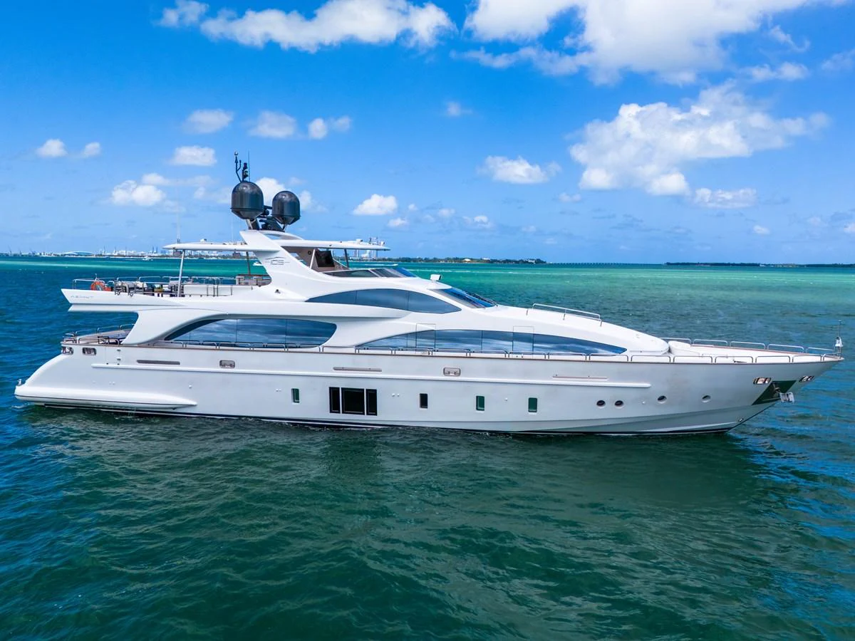 A sleek and modern yacht glides gracefully on clear blue waters under a bright sky. aboard AZIMUT GRANDE 105 Yacht for Sale