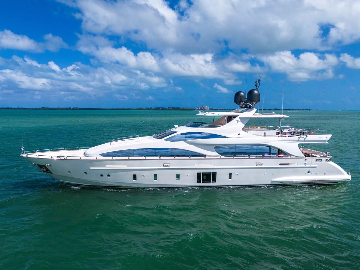 A sleek and modern yacht cruising on calm, turquoise waters under a bright blue sky. aboard AZIMUT GRANDE 105 Yacht for Sale